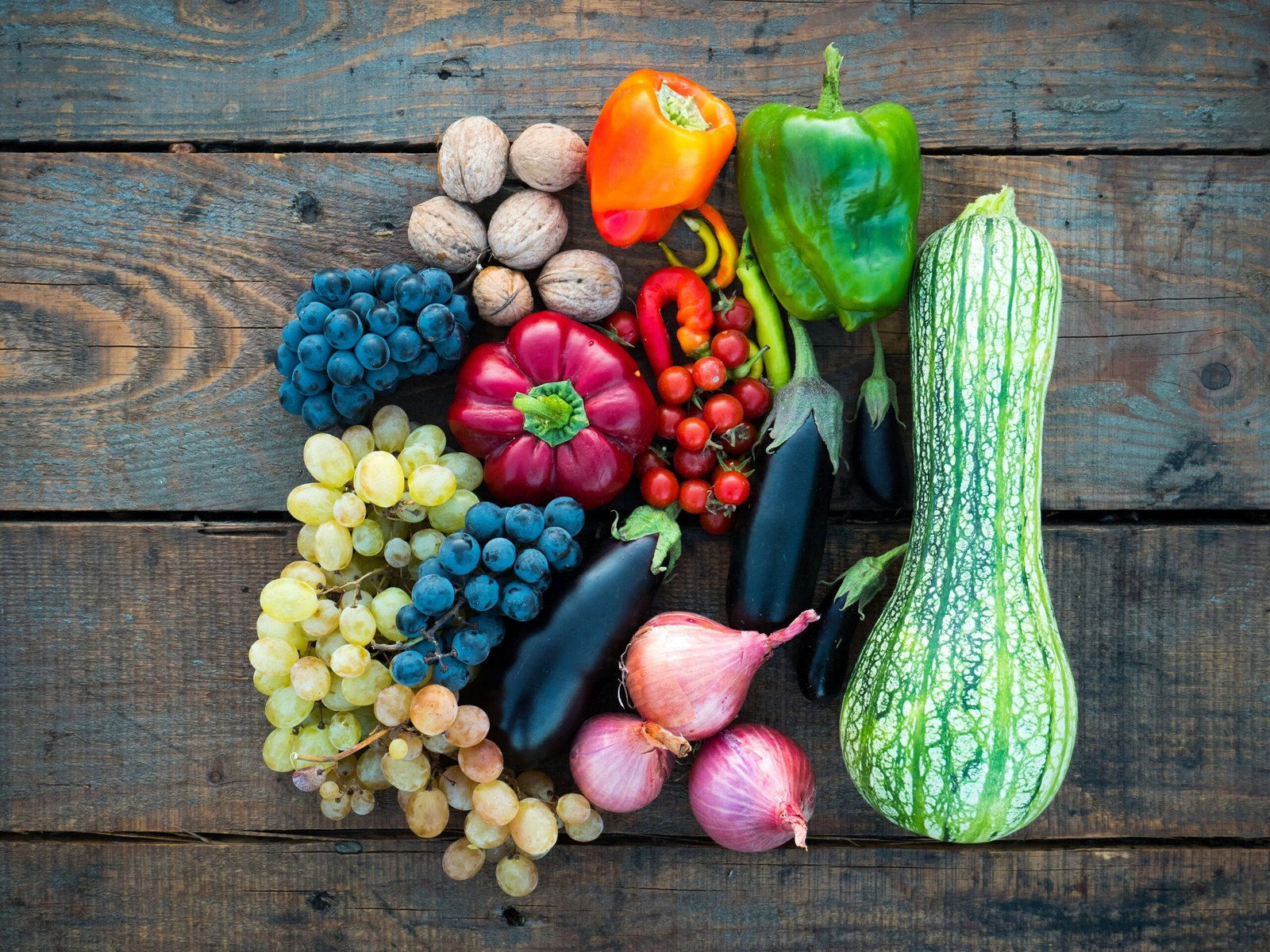 a variety of fruits and vegetables on a wooden surface